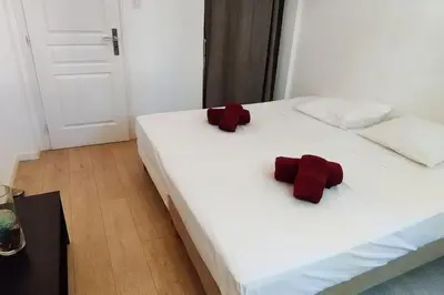 a white bed with two red ties on it at Le Canada - 2Pièces Croisette plage derrière le Carlton calme in Cannes