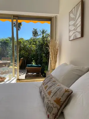 a bedroom with a bed with a view of a patio at Le Week Riviera III -3 étoiles-Plage du midi-Grande terrasse-Piscine-Cannes- Palais des Festivals in Cannes