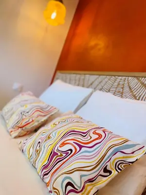 a bed with a colorful blanket on top of it at Le Week Riviera III -3 étoiles-Plage du midi-Grande terrasse-Piscine-Cannes- Palais des Festivals in Cannes