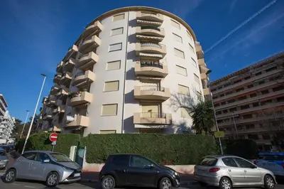a white building with cars parked in front of it at B018-Bright apartment with balcony - Cannes Croisette in Cannes