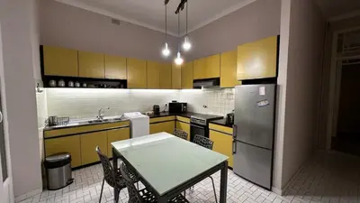 a kitchen with a table and a refrigerator at B011-Appartement familial - Proche de la plage in Cannes