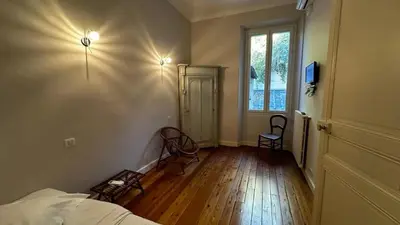 a bedroom with a bed and two chairs and a window at B011-Appartement familial - Proche de la plage in Cannes