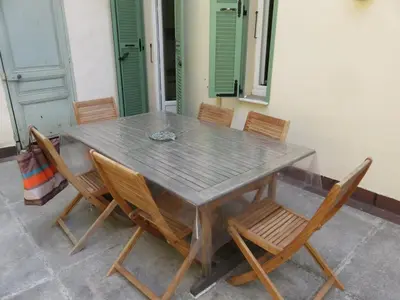 a wooden table and chairs with a table and a table and chairs at B011-Appartement familial - Proche de la plage in Cannes