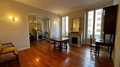 a living room with a table and a fireplace at B011-Appartement familial - Proche de la plage in Cannes
