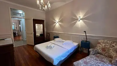 a bedroom with a bed and a couch and a chandelier at B011-Appartement familial - Proche de la plage in Cannes