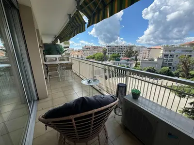 a balcony with a chair and a view of a city at B049-Appartement lumineux à deux pas de la Croisette in Cannes