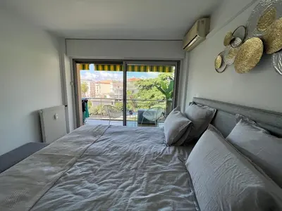 a bedroom with a large bed with a large window at B049-Appartement lumineux à deux pas de la Croisette in Cannes