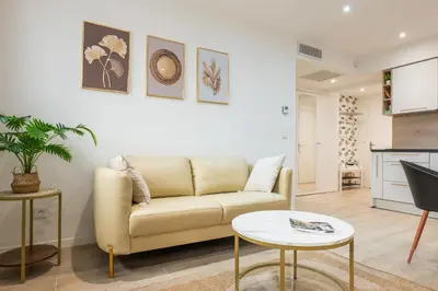a living room with a couch and a table at Upscale 3-room apartment 300m from the beaches in Cannes
