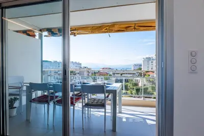 a dining room with a view of the city at 3-bedroom apartment sea view terrace and parking in Cannes