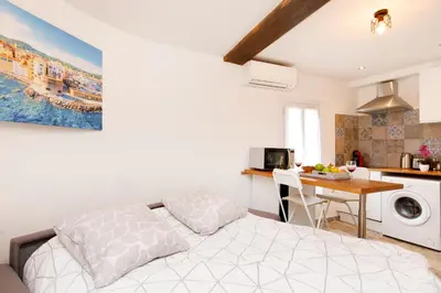 a bedroom with a bed and a kitchen with a table at Sweet Azur - Host Provence in Le Cannet