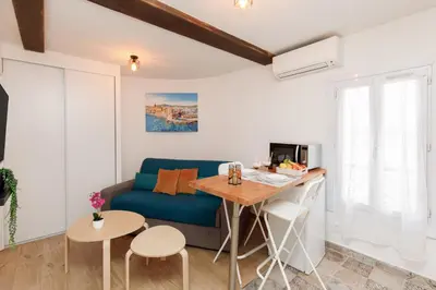 a living room with a blue couch and a table at Sweet Azur - Host Provence in Le Cannet