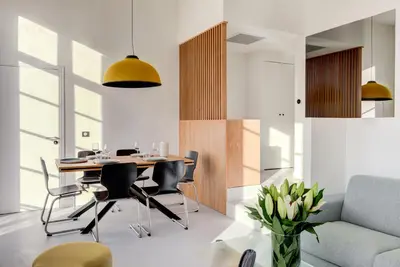 a dining room with a table and chairs and a couch at IMMOGROOM - Appartements luxueux - 2min du Palais - Vue mer - Clim in Cannes