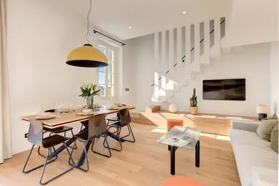 a dining room and living room with a table and a couch at IMMOGROOM - Appartements luxueux - 2min du Palais - Vue mer - Clim in Cannes
