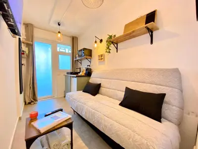 a living room with a couch and a table at Mini-Studio Le Cormoran By SCLS Locations in Cannes