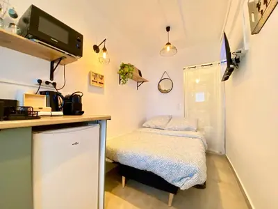 a small kitchen with a small bed in a room at Mini-Studio Le Cormoran By SCLS Locations in Cannes