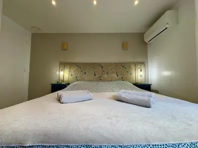 a bedroom with a large bed with two pillows on it at Les Jardins de Lérins By SCLS Locations in Cannes