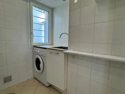 a kitchen with a washing machine and a window at Les Jardins de Lérins By SCLS Locations in Cannes