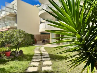 a garden with a stone path in front of a building at Les Jardins de Lérins By SCLS Locations in Cannes