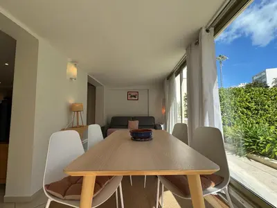 a dining room with a wooden table and chairs at Les Jardins de Lérins By SCLS Locations in Cannes
