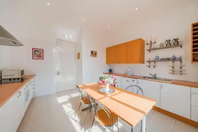 a kitchen with a wooden table and chairs at Cozystay 1249 - Gorgeous bourgeois apartment in Cannes