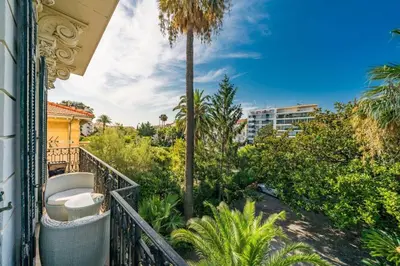 a balcony with a view of a palm tree at Cozystay 1249 - Gorgeous bourgeois apartment in Cannes