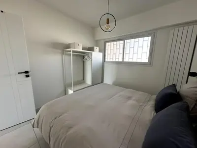 a white bedroom with a bed and a window at AGENCIA Superbe appartement Le Bellevue in Cannes