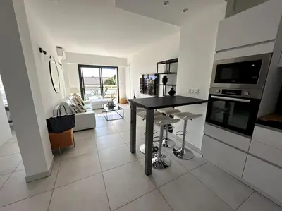 a kitchen and living room with a table in the middle at AGENCIA Superbe appartement Le Bellevue in Cannes
