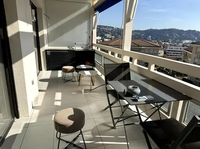 a balcony with chairs and a table on a building at AGENCIA Superbe appartement Le Bellevue in Cannes