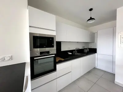 a kitchen with white cabinets and a stove top oven at AGENCIA Superbe appartement Le Bellevue in Cannes