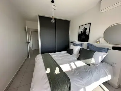 a bedroom with a large white bed with a large mirror at AGENCIA Superbe appartement Le Bellevue in Cannes