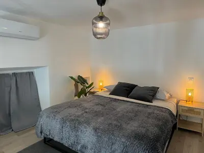 a bedroom with a bed and a pendant light at Studio Cosy, 5 minutes du Palais des festivals in Cannes