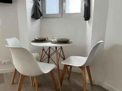 a dining room with white chairs and a table at Studio Cosy, 5 minutes du Palais des festivals in Cannes