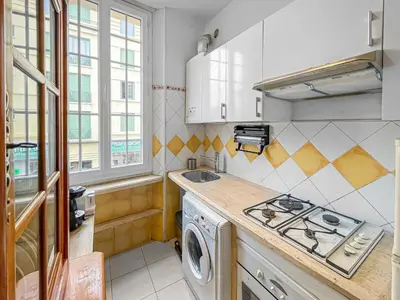 a kitchen with a stove and a washing machine at Chic Cannois Proche de la Croisette in Cannes