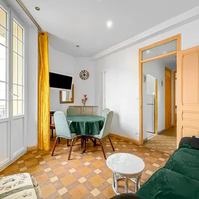 a living room with a green table and chairs at Chic Cannois Proche de la Croisette in Cannes