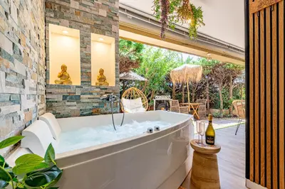a bath tub in a room with a patio at LA VILLA BALI A CANNES in Cannes