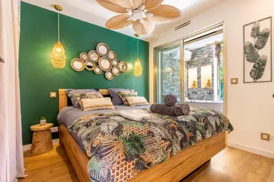 a bedroom with a bed and a green wall at LA VILLA BALI A CANNES in Cannes