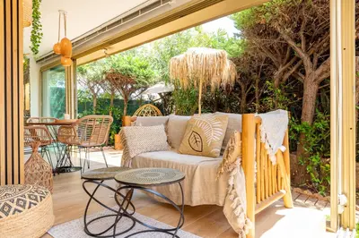 a screened in porch with a couch and a table at LA VILLA BALI A CANNES in Cannes