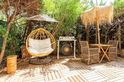 a patio with a chair and a table and a grill at LA VILLA BALI A CANNES in Cannes