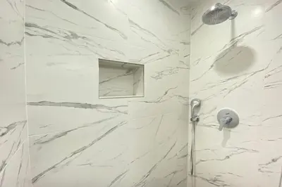 a bathroom with white marble walls and a shower at Beautiful 2 bedrooms 2 bathrooms Center of Cannes in Cannes