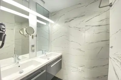 a white bathroom with a sink and a mirror at Beautiful 2 bedrooms 2 bathrooms Center of Cannes in Cannes