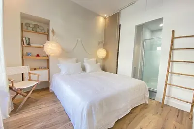 a bedroom with a large white bed and a chair at Beautiful 2 bedrooms 2 bathrooms Center of Cannes in Cannes
