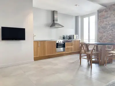 a kitchen with a table and a television in it at BAT2 - Cannes, Carré d'Or, beau 2 pièces in Cannes