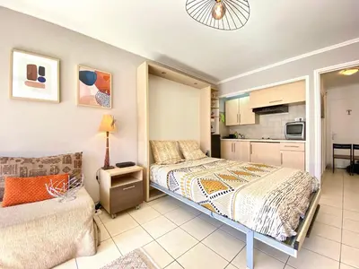 a small bedroom with a bed and a kitchen at Terracotta - Proche Palais des Festivals - By SCLS Locations in Cannes