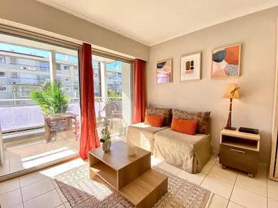 a living room with a bed and a large window at Terracotta - Proche Palais des Festivals - By SCLS Locations in Cannes