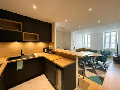 a kitchen with black cabinets and a dining room at Appartements Centre Cannes in Cannes
