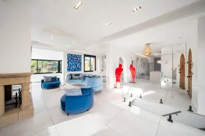 a living room with blue furniture and a fireplace at REF 2134 - Cannes - Magnificent villa for rent in Cannes