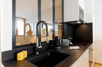 a kitchen with a sink and two faucets at My Ty Croisette Martinez YourHostHelper in Cannes