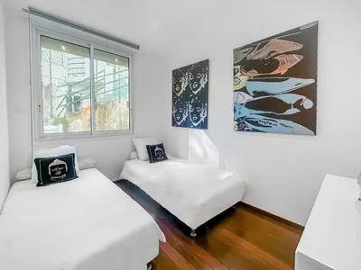 a room with two beds and a window at La Perle de Cannes in Cannes