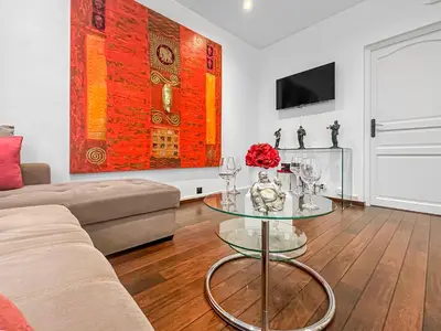 a living room with a couch and a glass table at La Perle de Cannes in Cannes