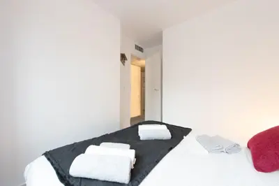 a white room with a bed with towels on it at Le Coquillage - 200 mètres de la Plage in Cannes